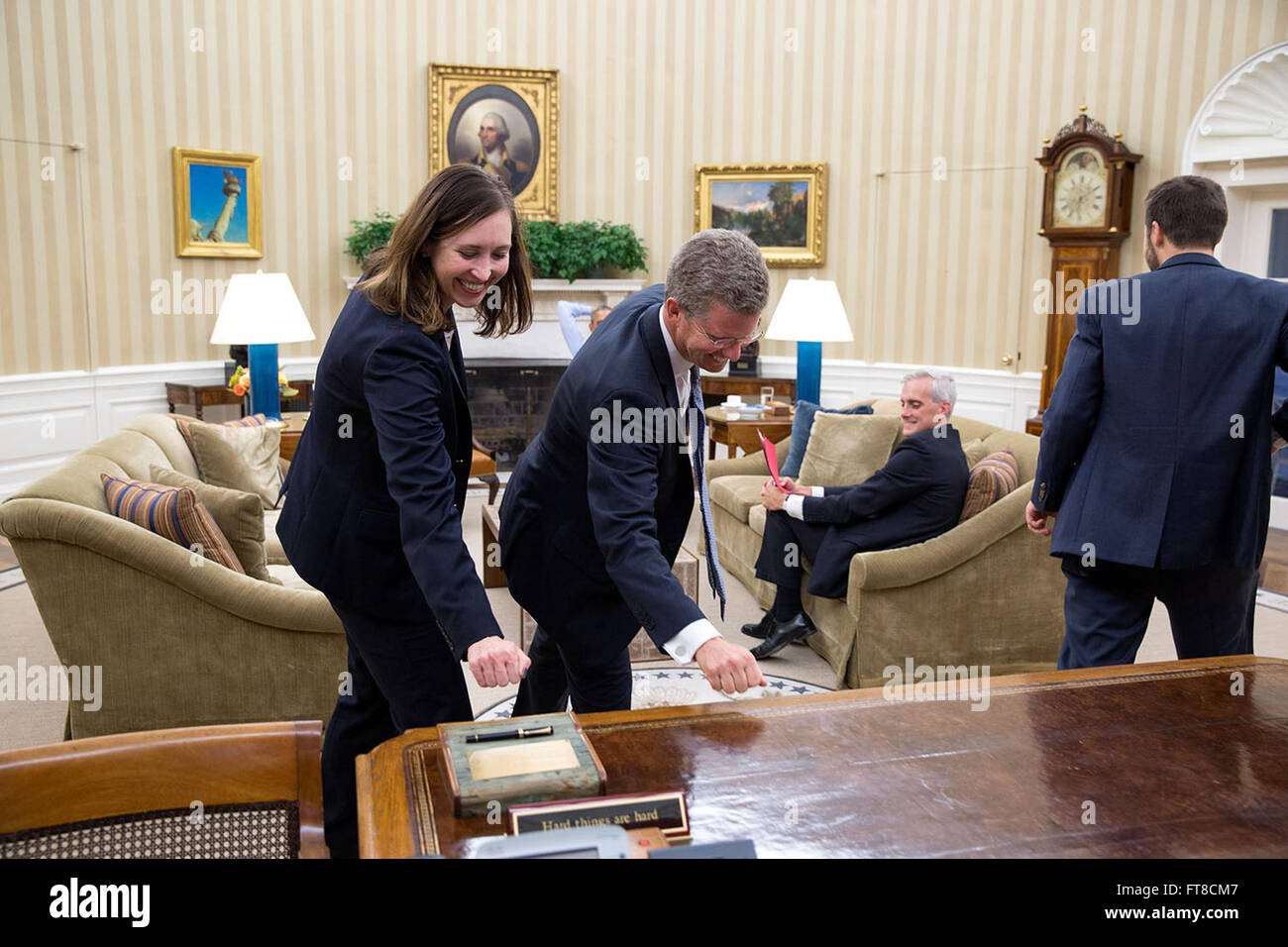 Questa fotografia del 2015 di Pete Souza cattura Katie Beirne Fallon e Shaun Donovan dopo il loro incontro con il presidente, bussando al Resolute Desk con un gesto di speranza per il passaggio del bilancio attraverso il Congresso. Foto Stock