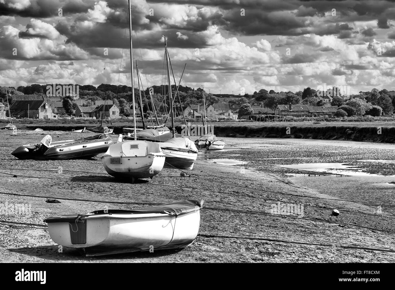 Blakeney quay a bassa marea con i gommoni e piccole imbarcazioni tirata fuori Foto Stock