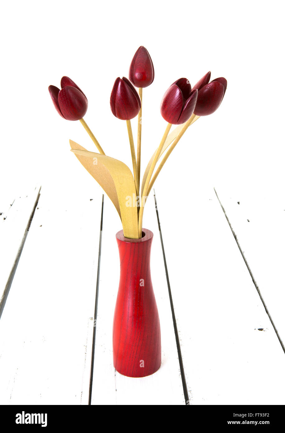 Cinque tulipani rossi in un vaso di legno su un bianco sullo sfondo di legno Foto Stock