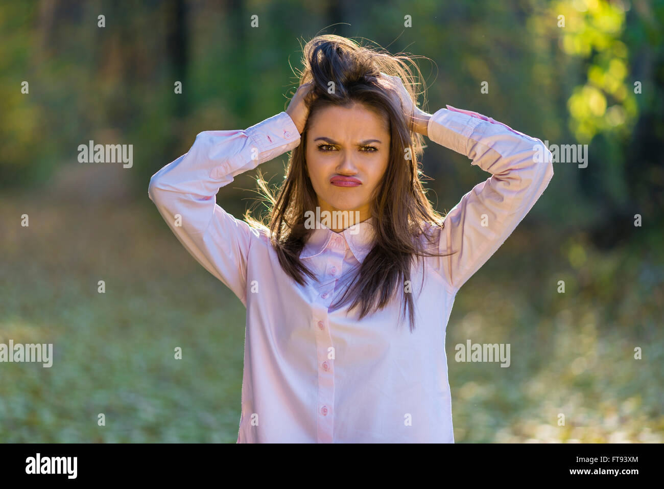Una graziosa adolescente simpatiche ragazza sta tenendo la testa con le mani come la sua vita è piena di problemi diversi. Foto Stock