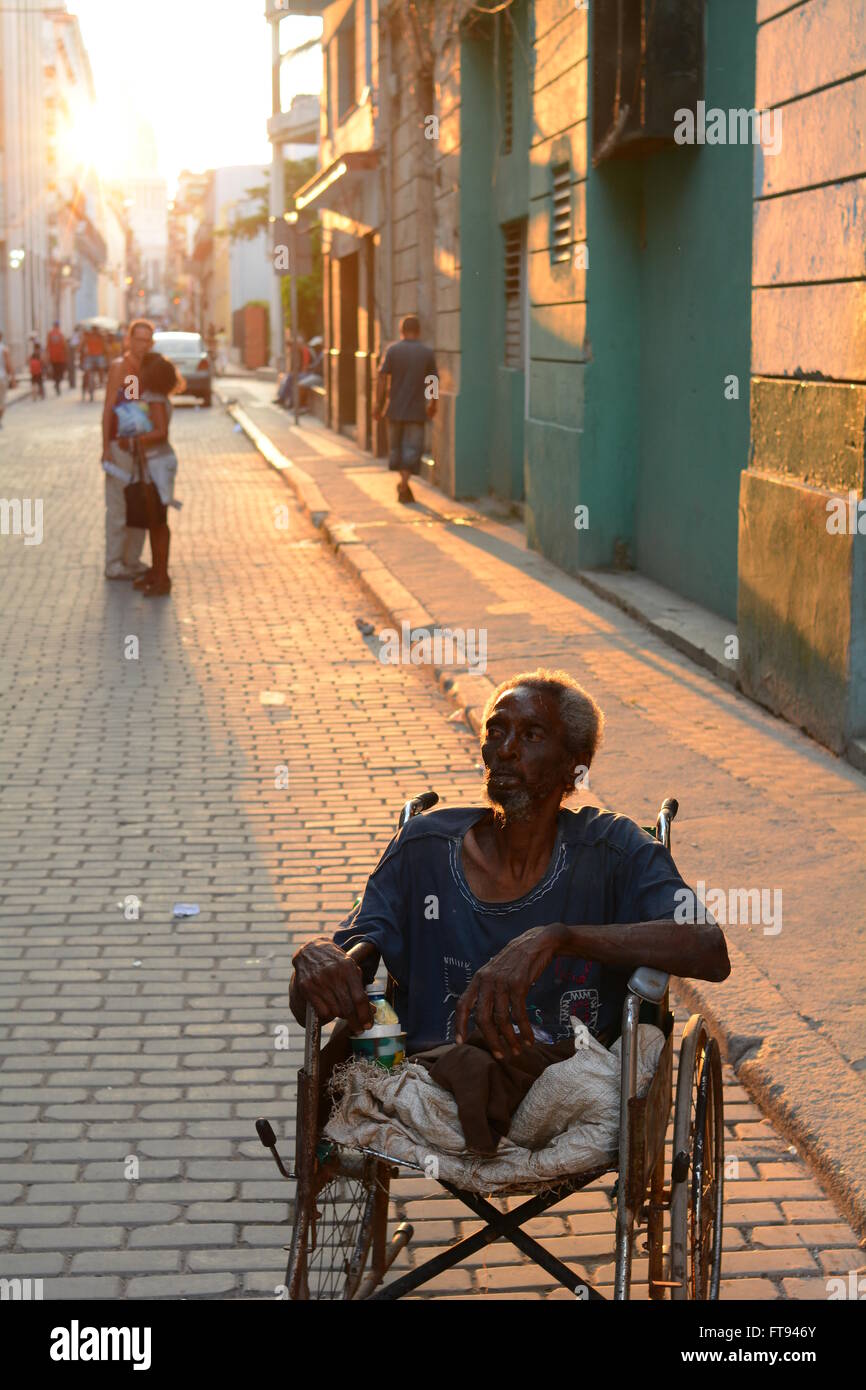 Un uomo disabili in sedia a rotelle nella Strada Vecchia Havana Foto Stock