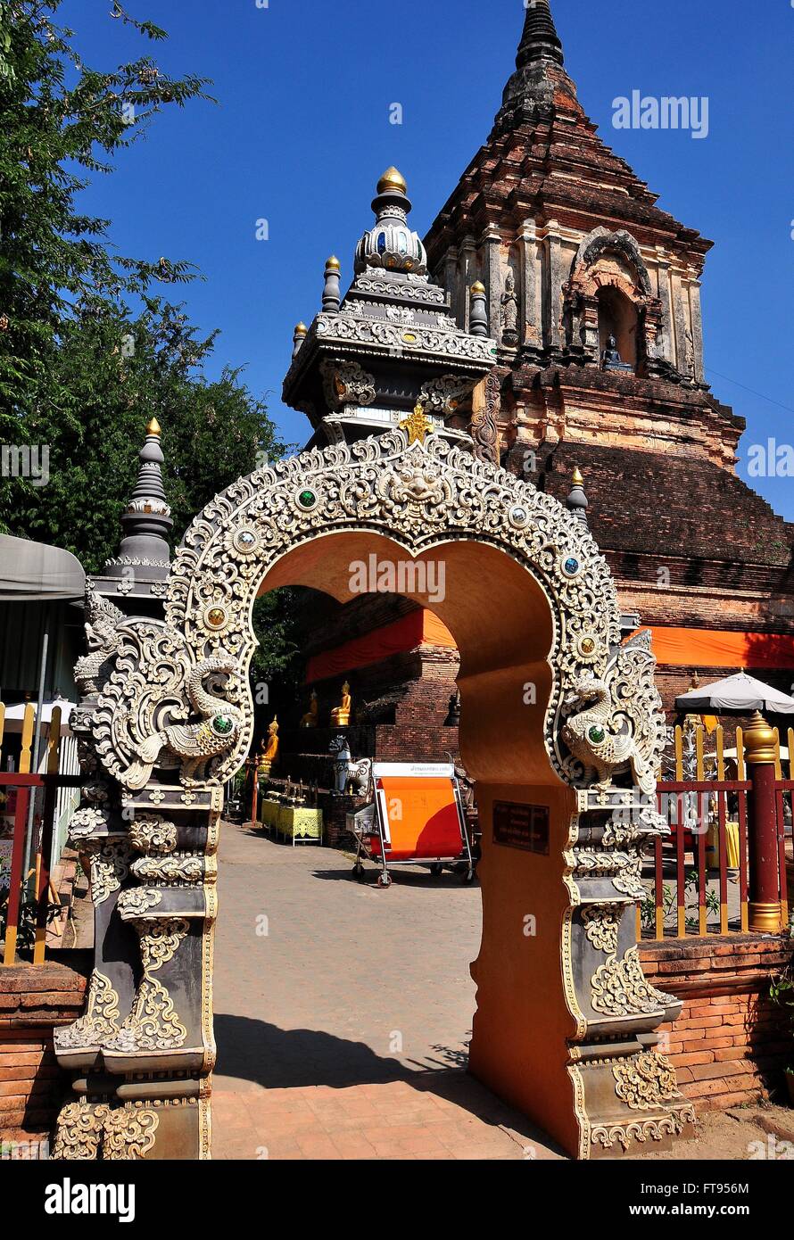 Chiang Mai, Thailandia: secolare grande in mattoni e pietra Chedi e riccamente intagliato porta d ingresso al Wat Lok Molee * Foto Stock