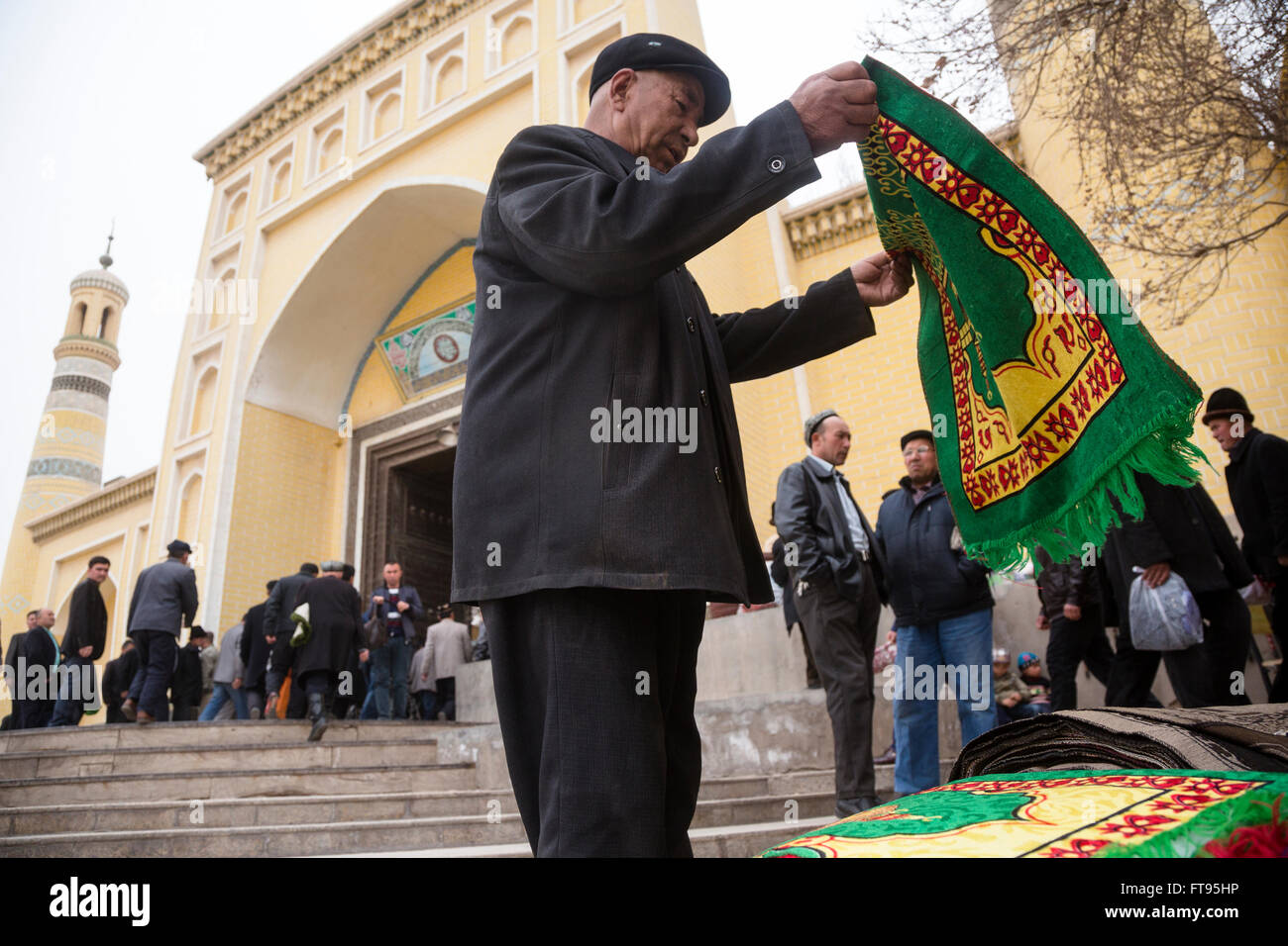 Musulmani acquista un tappeto prima della preghiera del venerdì all'ingresso del più grande in Cina alla Moschea Id kah di Kashgar city Foto Stock