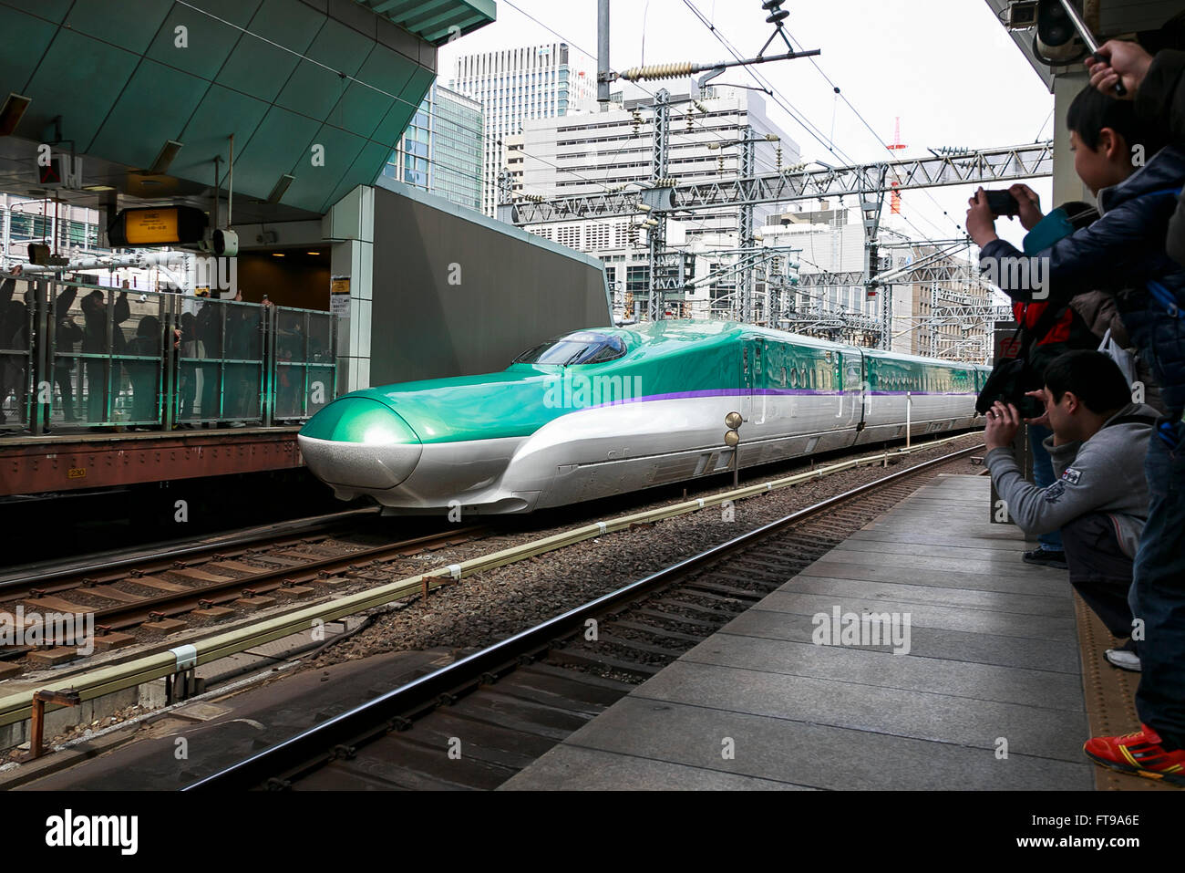 Tokyo, Giappone. 26 Mar, 2016. La Hayabusa Shinkansen (treno veloce) arriva alla Stazione di Tokyo nel suo primo giorno di funzionamento su Marzo 26, 2016, Tokyo, Giappone. La Hayabusa shinkansen collega Tokyo con l'isola settentrionale di Hokkaido attraverso il 53.85 km lungo tunnel Seikan. In precedenza il Giappone del bullet train azionato solo per quanto Aomori ma il nuovo collegamento ferroviario va ora a Shin-Hakodate-stazione di Hokuto in Hokkaido con un ulteriore ampliamento previsto a Sapporo dal 2030. Un biglietto di sola andata costa 22,690 yen (200 UDS) da Tokyo a Shin-Hakodate Hokuto e il più veloce dei treni si impiegano 4 ore e 2 minuti per t Foto Stock