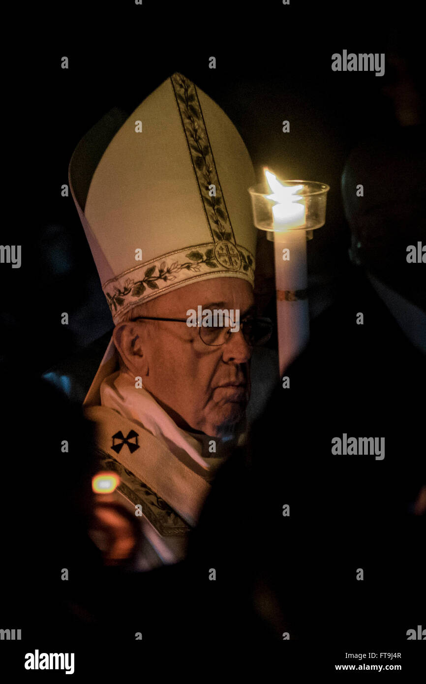 Città del Vaticano il Vaticano. 26 Mar, 2016. Papa Francesco tiene in mano il cero pasquale come egli arriva a celebrare la Veglia Pasquale nella Notte Santa Messa nella Basilica di San Pietro in Vaticano Città del Vaticano. La celebrazione della Veglia Pasquale inizia con la benedizione della fiamma pasquale nell atrio della Basilica di San Pietro. Il cero pasquale viene quindi portato in processione nella Chiesa. Dopo che il diacono canta l'Exultet, l antico inno che loda la risurrezione. Credito: Giuseppe Ciccia/Pacific Press/Alamy Live News Foto Stock
