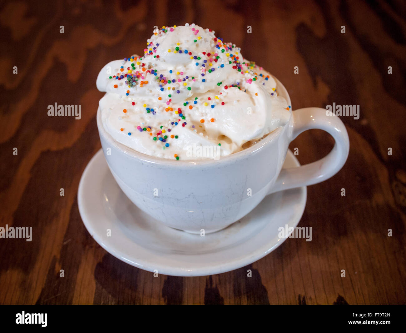 Un caldo Torta di compleanno latté con granelli colorati e panna montata dal d'Lish da Tish Café di Saskatoon, Saskatchewan, Canada. Foto Stock