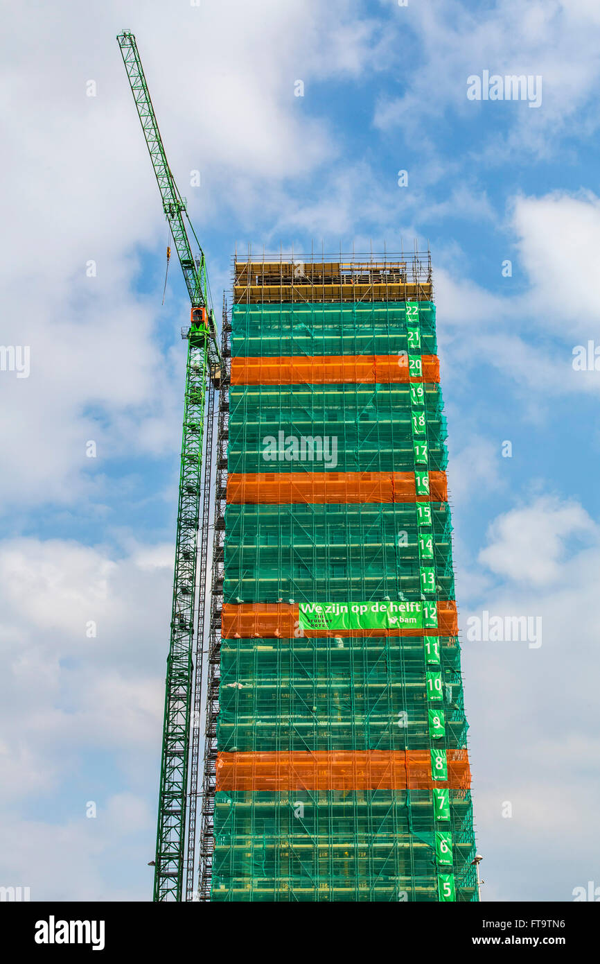 Sito in costruzione di un edificio alto, grattacielo, numerate pavimenti, tarp intorno all'edificio, Foto Stock