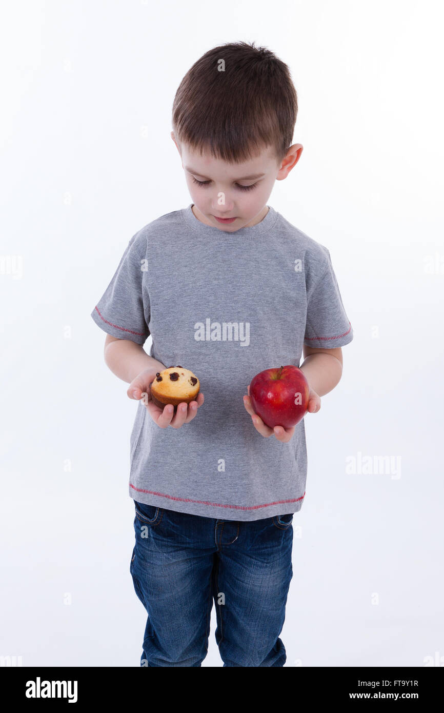 Little Boy con cibi isolati su sfondo bianco - Apple o un muffin Foto Stock