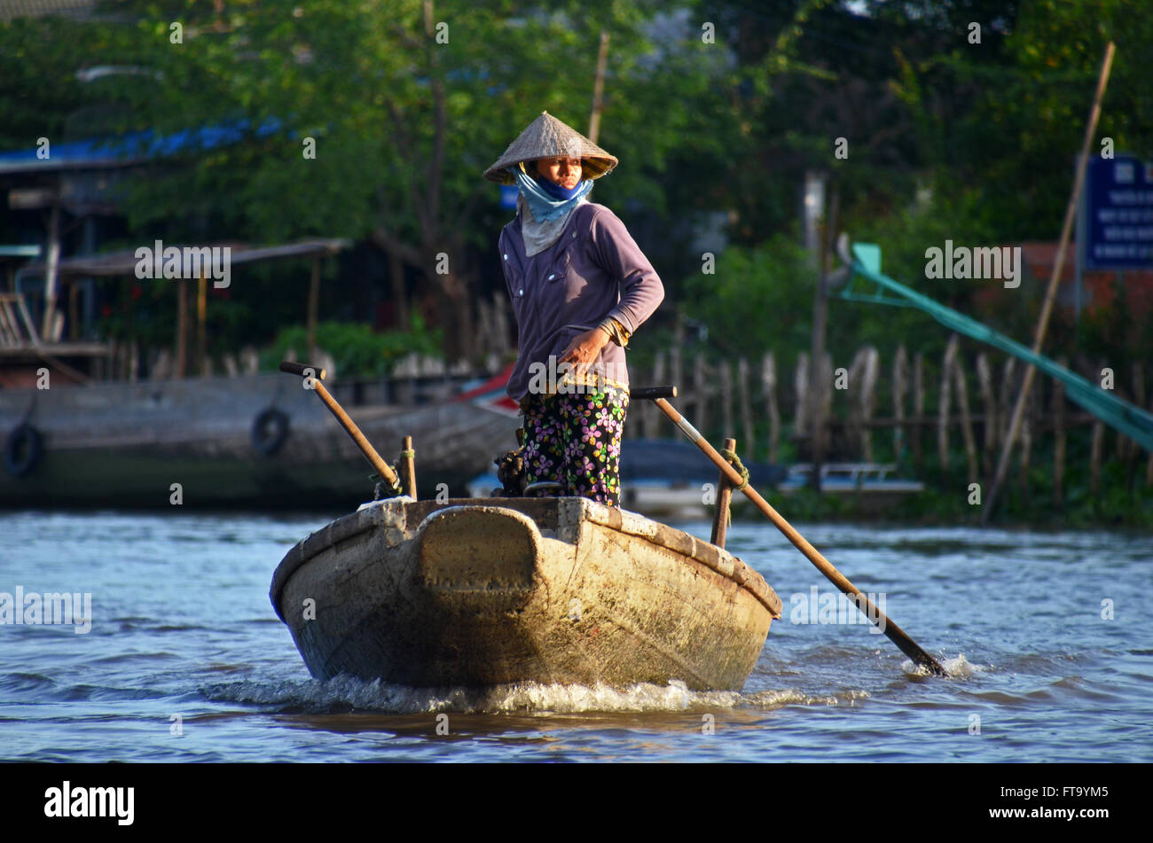 Una donna piloti una barca vicino a Cai Rang mercato galleggiante nel Delta del Mekong, Can Tho, Vietnam Foto Stock