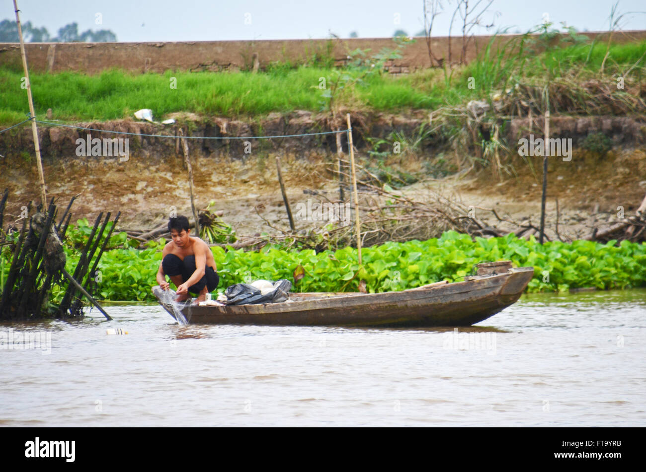 Un pescatore controlla la sua rete sul fiume Mekong tra Chau Doc, Vietnam, e Phnom Penh Cambogia Foto Stock
