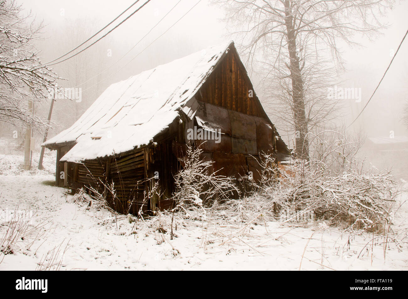 Il vecchio cottage di legno coperto da neve whithe Foto Stock
