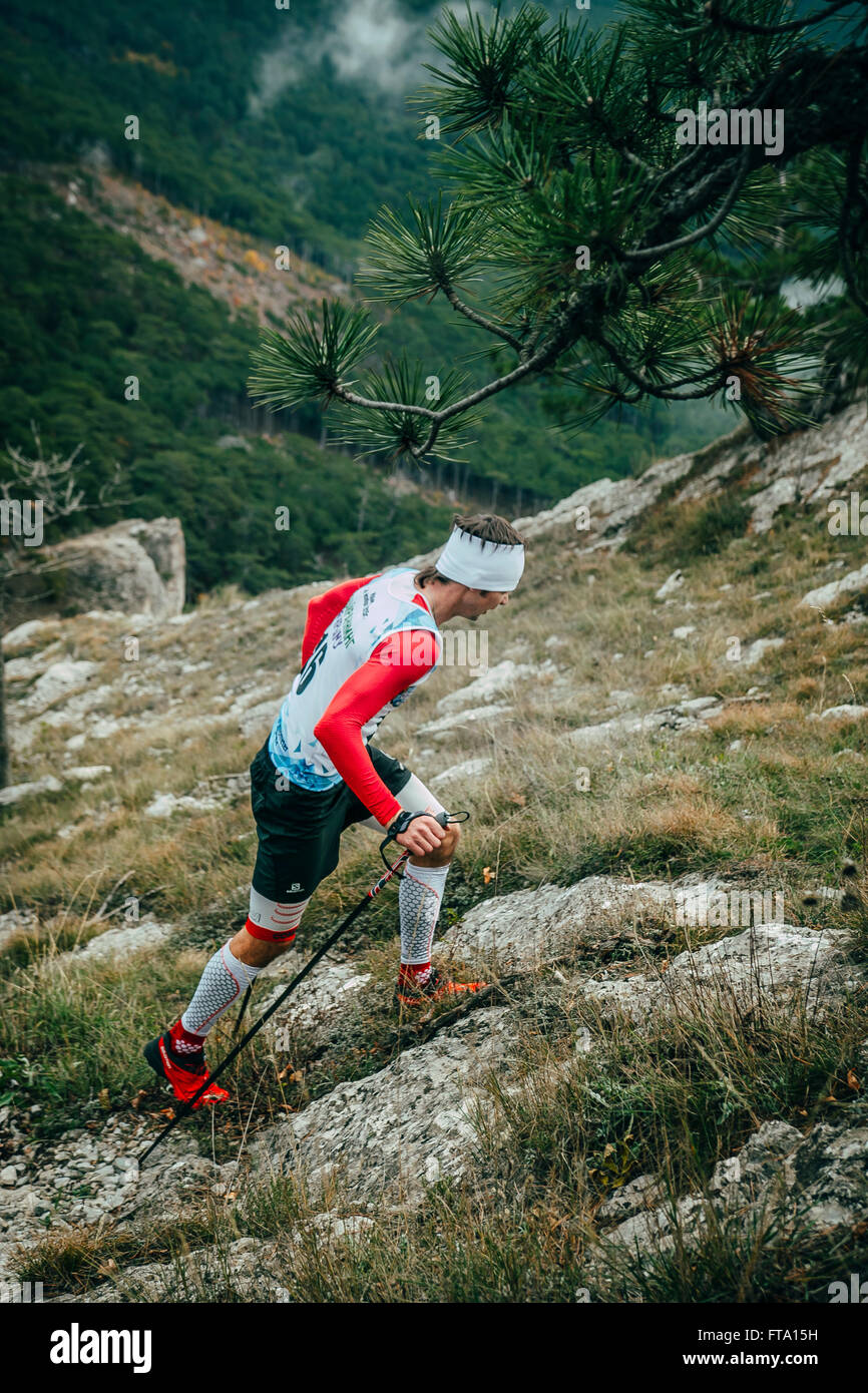 Atleta maschio salite a piedi in salita durante la maratona di montagna Foto Stock