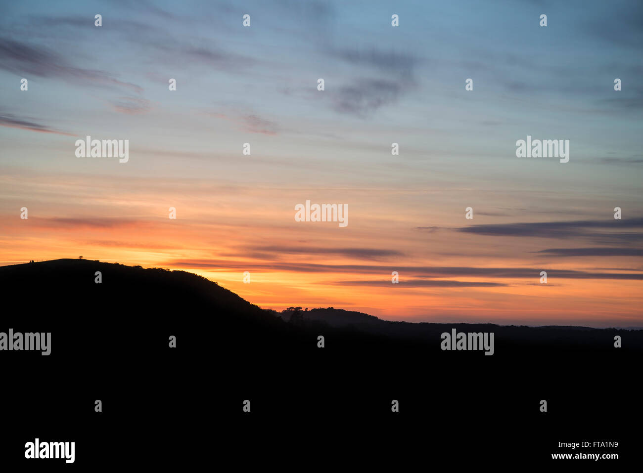 Vibrante paesaggio tramonto su campagna colline silhouette Foto Stock