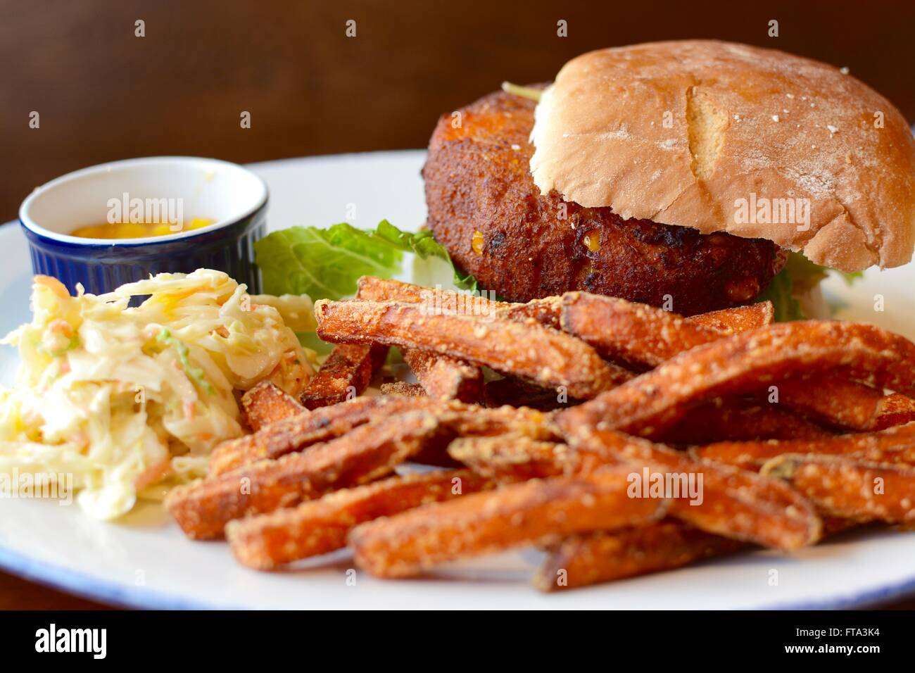 Hamburger vegetali in un panino con patate dolci patatine fritte, coleslaw e assaporare Foto Stock
