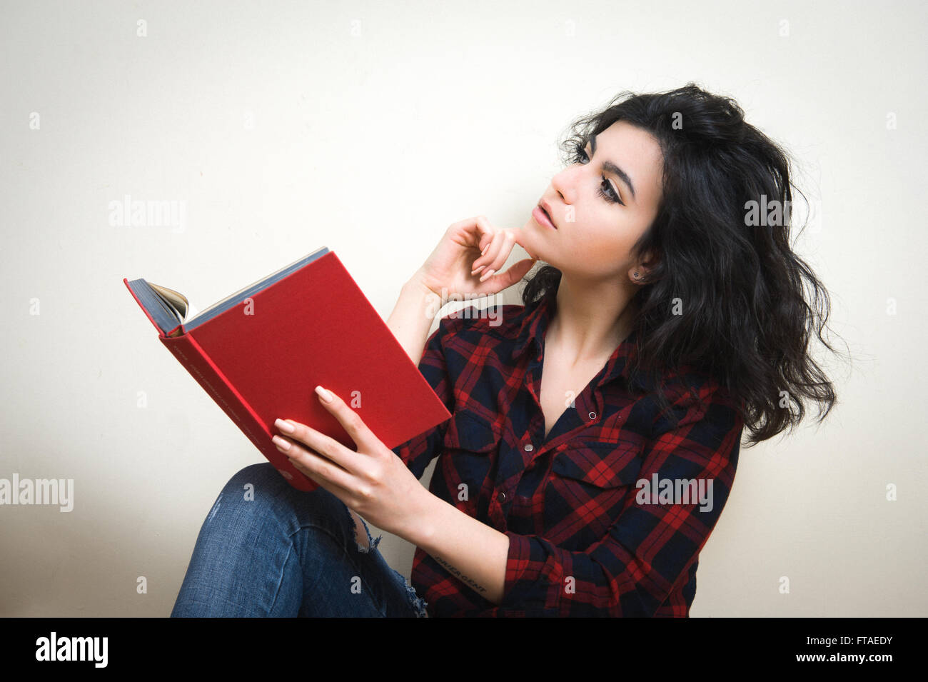 Donna giovane studente con libretto rosso su sfondo bianco Foto Stock