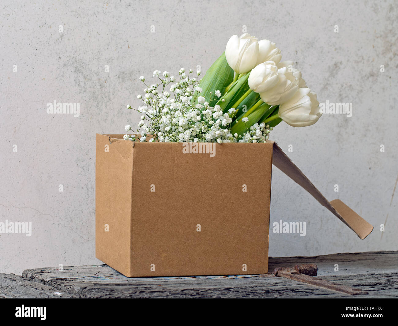 Bellissimi fiori di primavera. Shabby Chic in una scatola di cartone sul comò rustico. Foto Stock