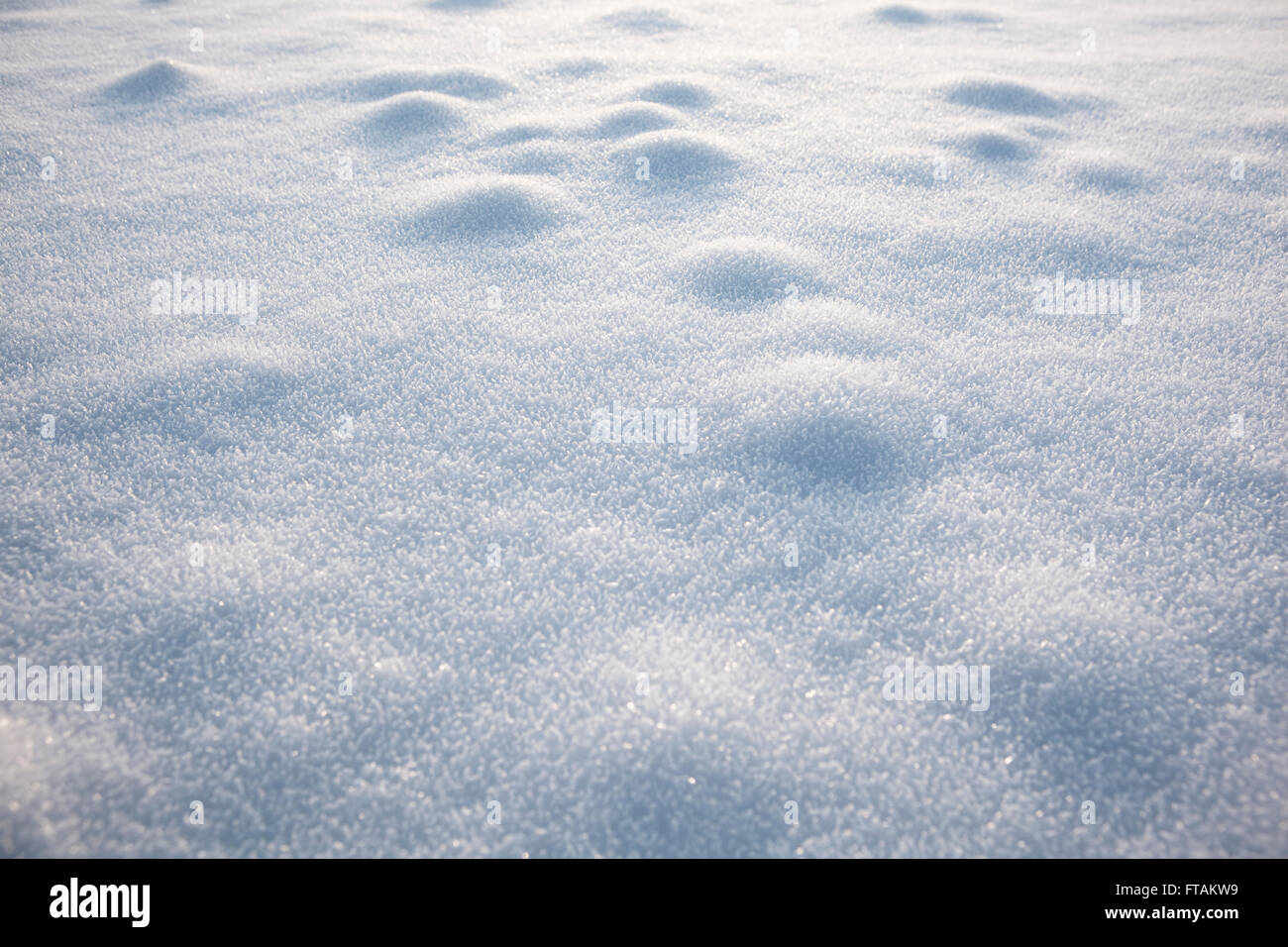 Neve si trova sulla campagna adn crea modelli astratti come esso riflette la luce dalle sue forme di cristallinità visto in rilievo. Foto Stock