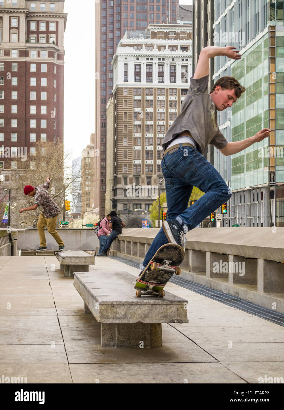 Città urbana scena di giovani uomini lo skateboard su una piazza pubblica nel centro cittadino di Philadelphia, Pennsylvania, STATI UNITI D'AMERICA Foto Stock