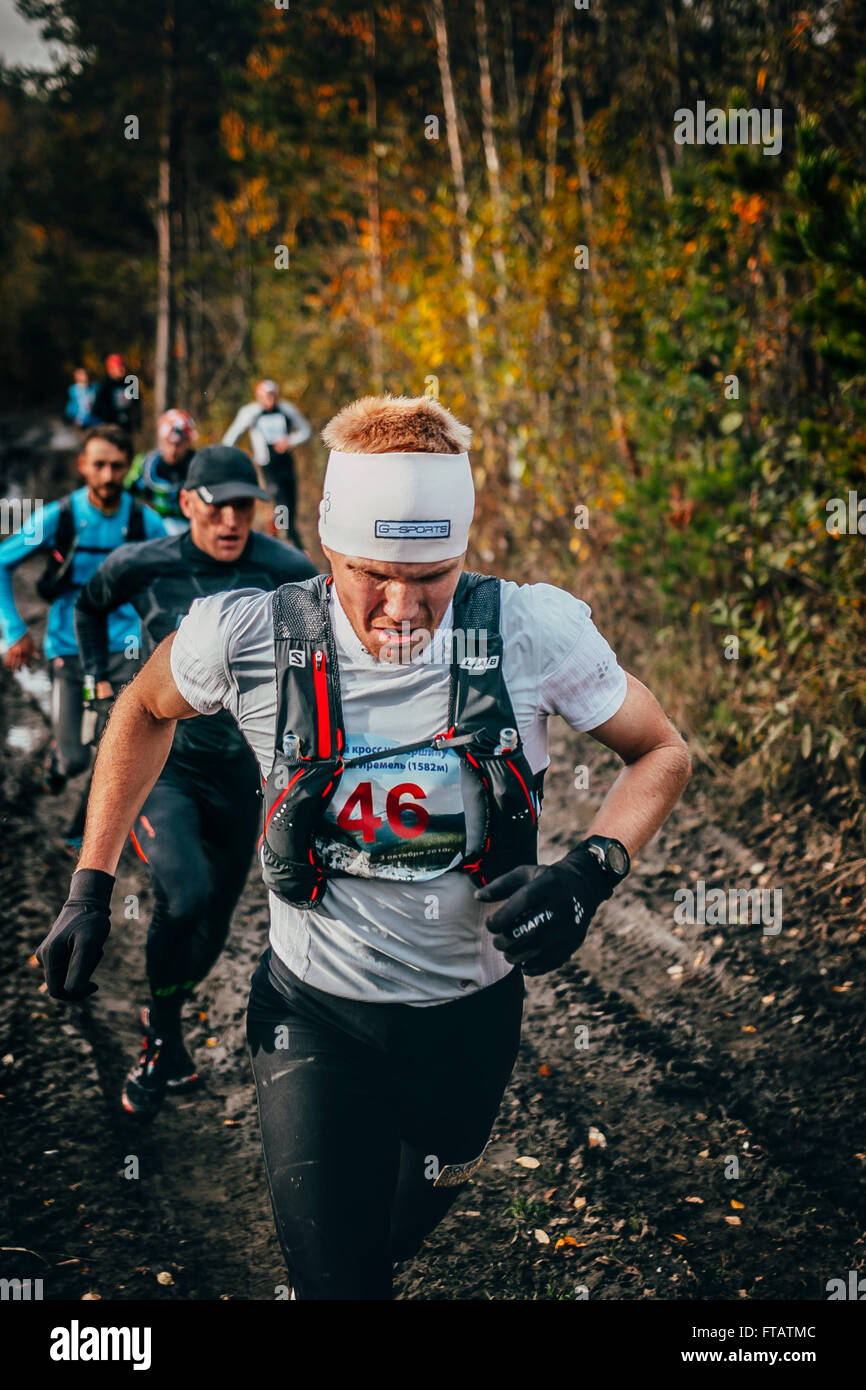 Beloretsk, Russia - 26 Settembre 2015: guide maschio eseguire il gruppo su una strada sterrata nel bosco durante la maratona mountain 'Big Iremel' Foto Stock