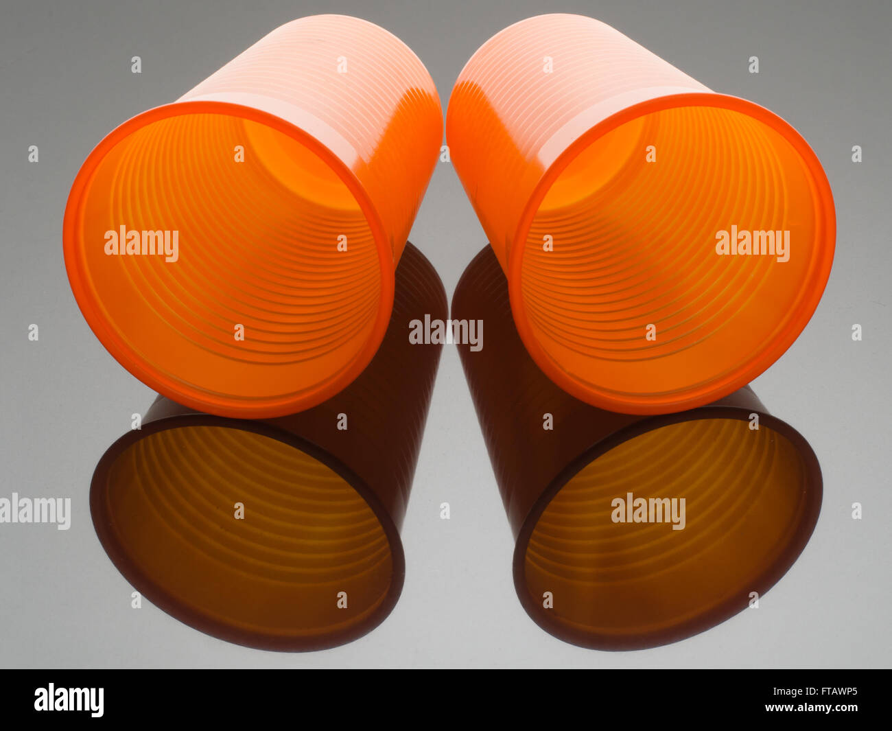 Arancio brillante tazze di plastica e con la riflessione Foto Stock