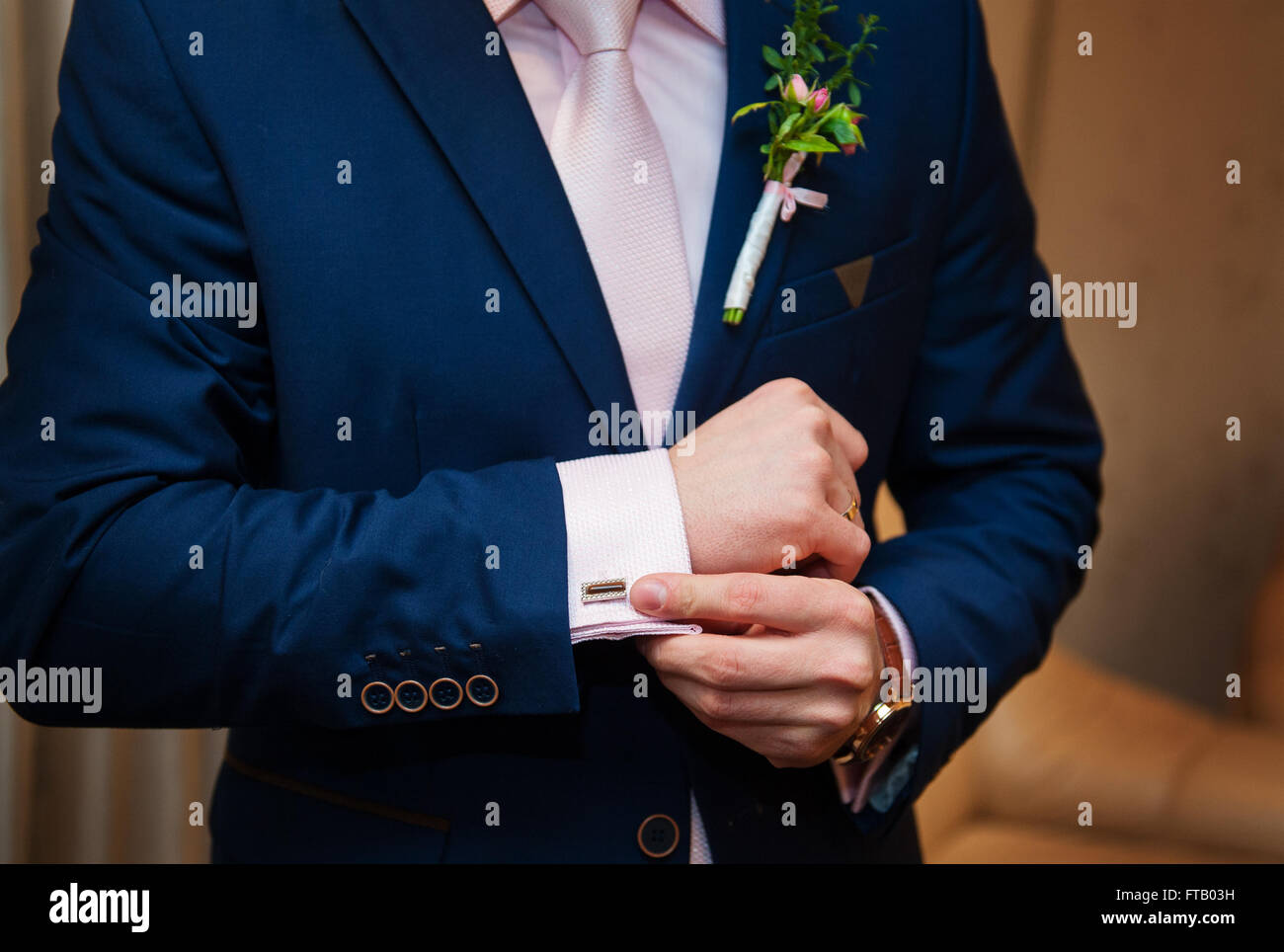 Le mani del matrimonio lo sposo in una camicia bianca dress gemelli Foto Stock
