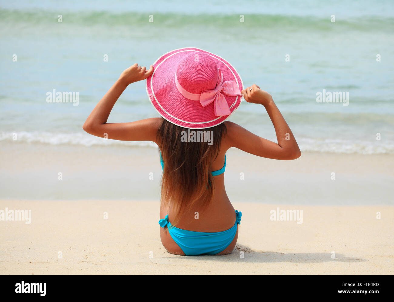 Donna in grande cappello seduto sulla spiaggia in riva al mare Foto stock -  Alamy