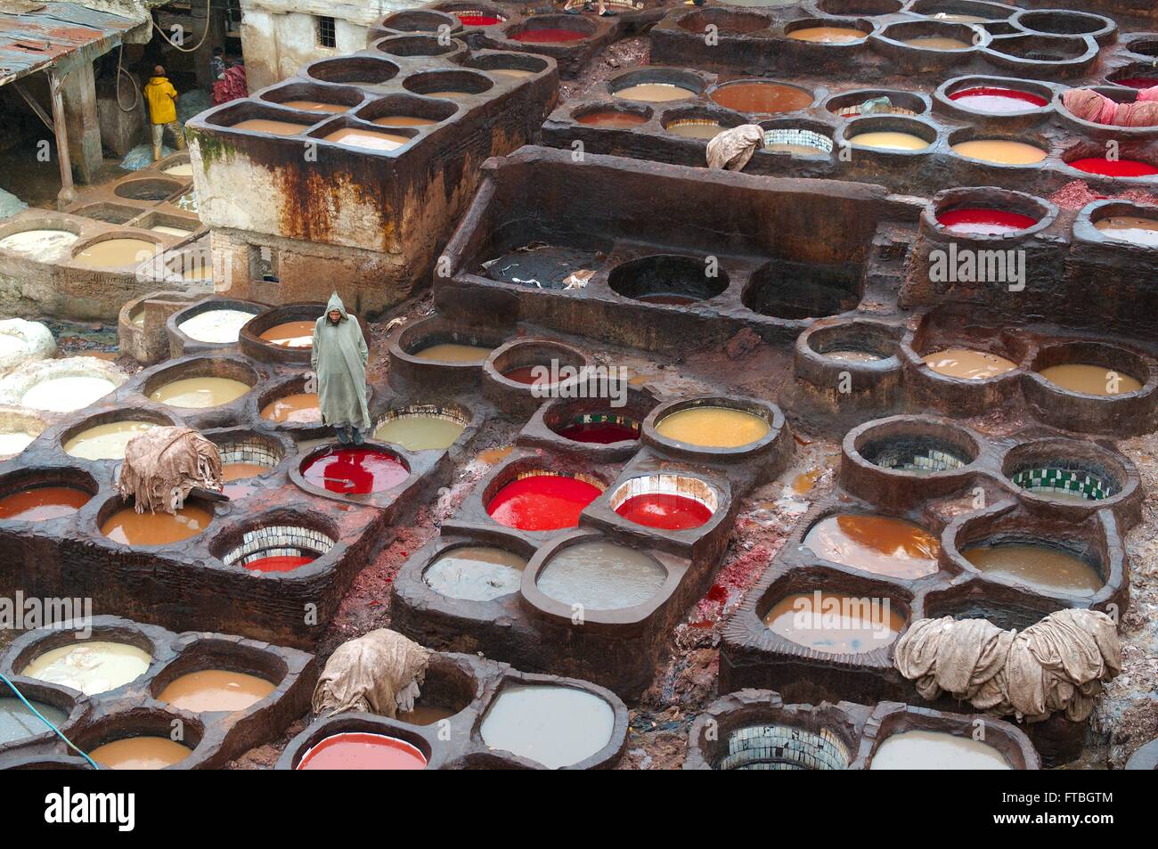 Un lavoratore marocchino coloranti a mano le pelli di animali con i serbatoi riempiti con i colori alla conceria Chouara all'interno del cuoio Souq Aprile 26, 2009 in Fez, in Marocco, Venerdì, 20 giugno 2014. L'antica Conceria ha operato a partire dal XI secolo e continua ad utilizzare le tecniche tradizionali e coloranti. Foto Stock