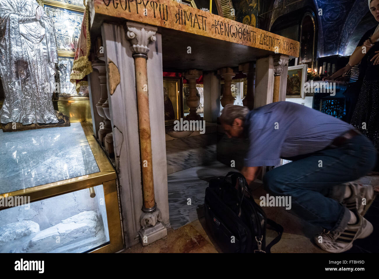 Coda di pellegrini a toccare la roccia del Calvario nella Cappella della Crocifissione nel Santo Sepolcro Chiesa, la Città Vecchia di Gerusalemme, Israele Foto Stock
