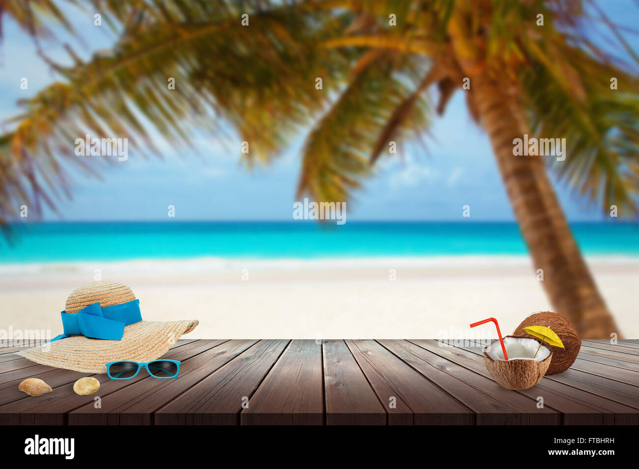 Cappello, occhiali da sole, noce di cocco, shell sulla spiaggia tabella. Spazio libero per il testo. Spiaggia, mare, Palm e cielo blu in background. Foto Stock