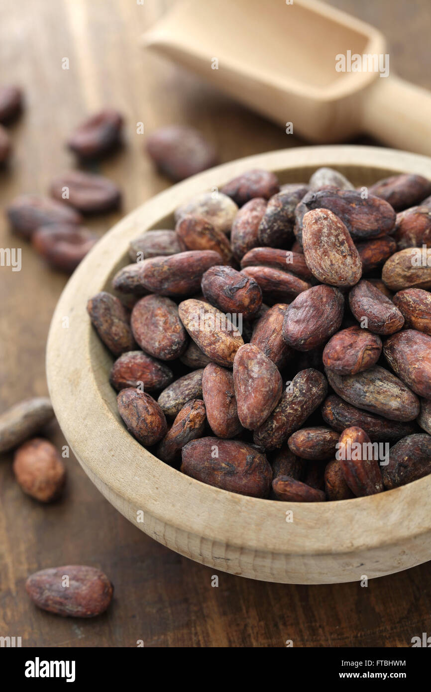 Materie cacao cacao in grani nella ciotola di legno Foto Stock