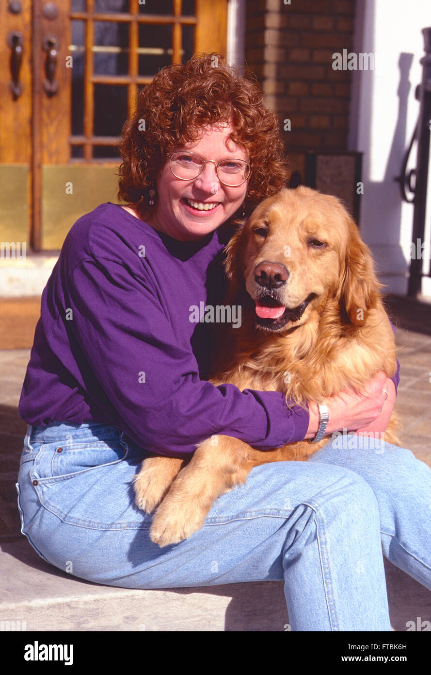 Outdoor ritratto di donna di mezza età con il suo Golden Retriever cane Foto Stock