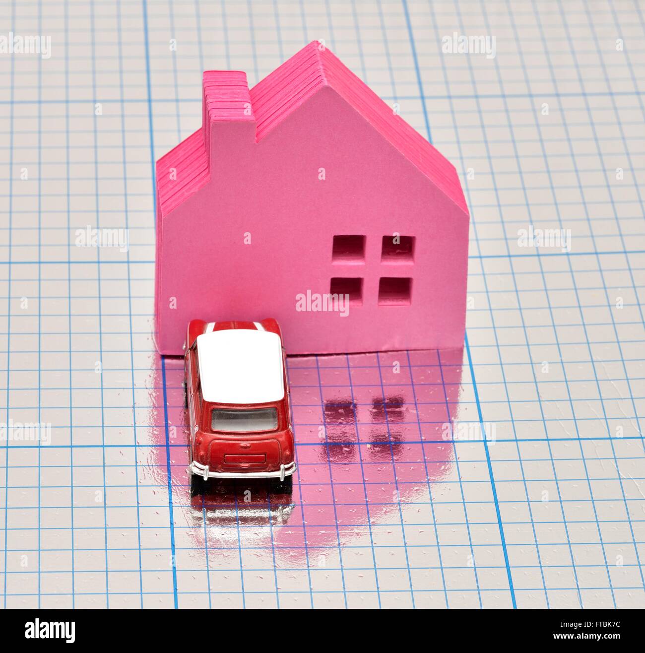 Una casa rosa con una vettura parcheggiata di fronte su un quadrato blu superficie lucida Foto Stock