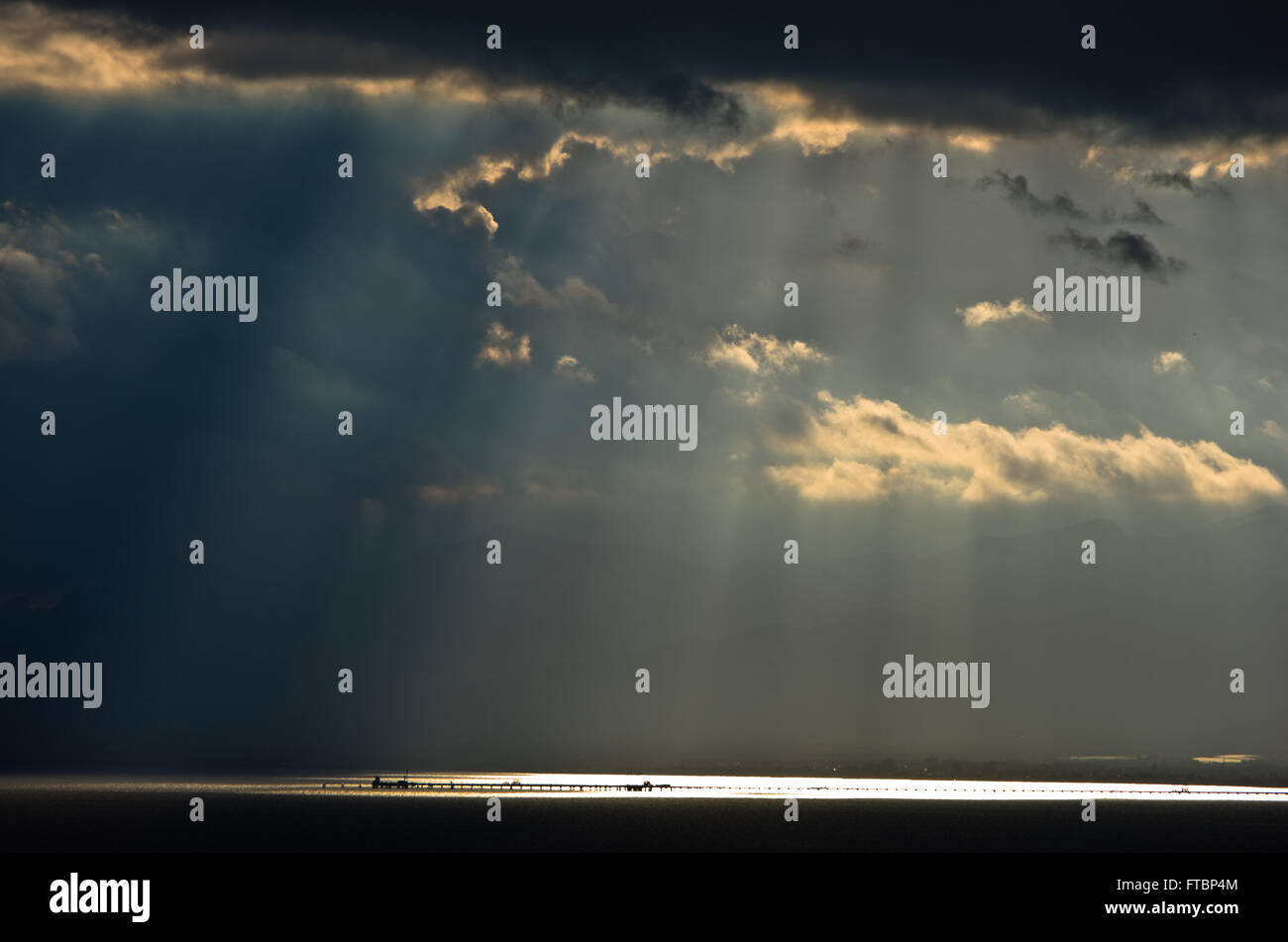 La luce divina su un lungo molo dopo una tempesta di mare in Sardegna Foto Stock