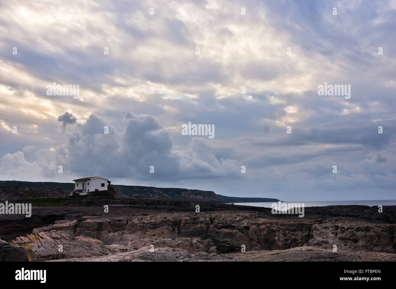 Casa isolata su una costa rocciosa di Isola di San Pietro, Sardegna Foto Stock