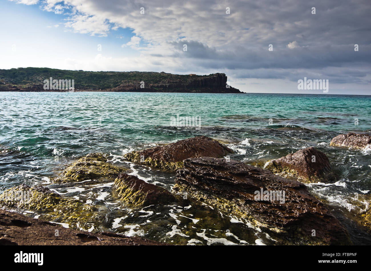 Rocce di mare e le onde a spiaggia di Isola di San Pietro, Sardegna Foto Stock