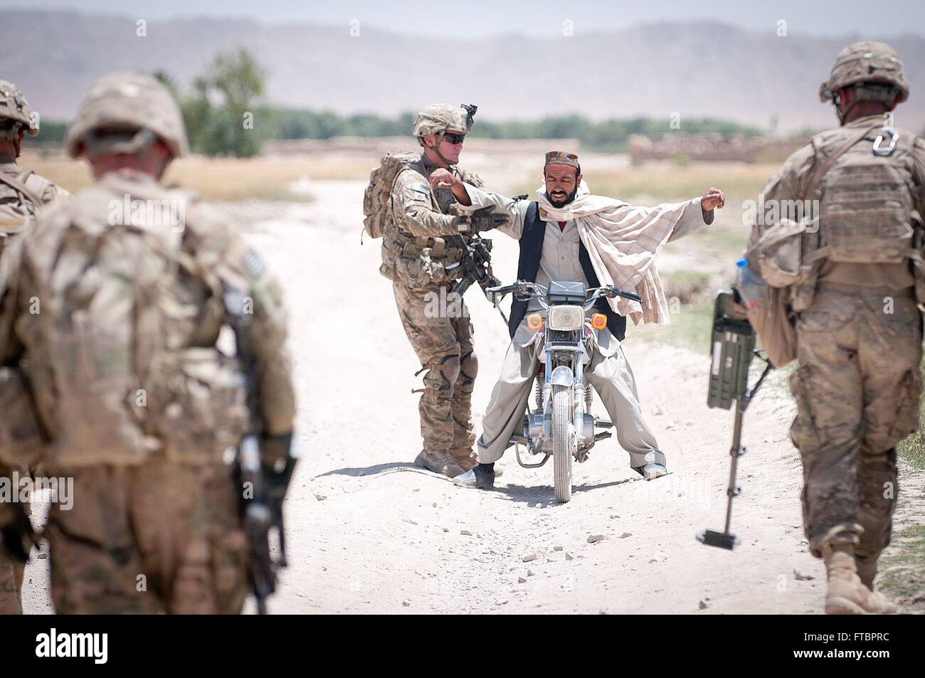 Stati Uniti Paracadutisti dell'esercito con l'ottantaduesima Airborne Division fermare un motociclista alla ricerca durante una scansione per congegni esplosivi improvvisati lungo una strada mentre di pattuglia Giugno 30, 2012 in provincia di Ghazni, Afghanistan. Foto Stock