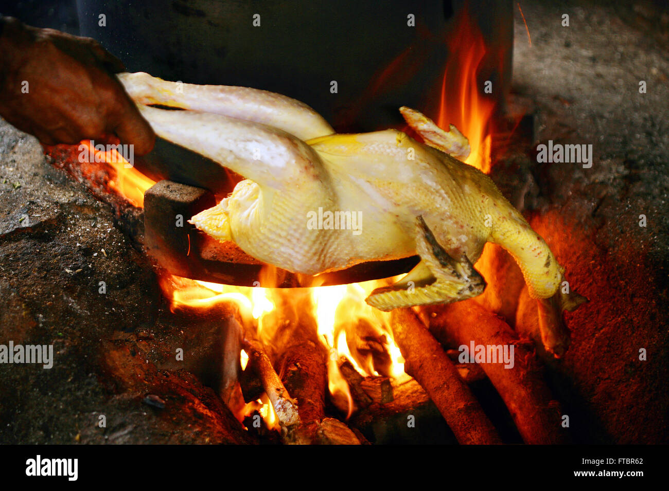 singeing pollo al fuoco, pronto per la cottura . Singe pollo fuoco per Chettinad pollo curry.Rural villaggio indiano che singeing le piume fuori un pollo Foto Stock
