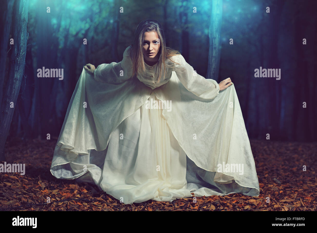 Bella donna chinandosi in ethereal fairy forest . Fantasia e surreale Foto Stock