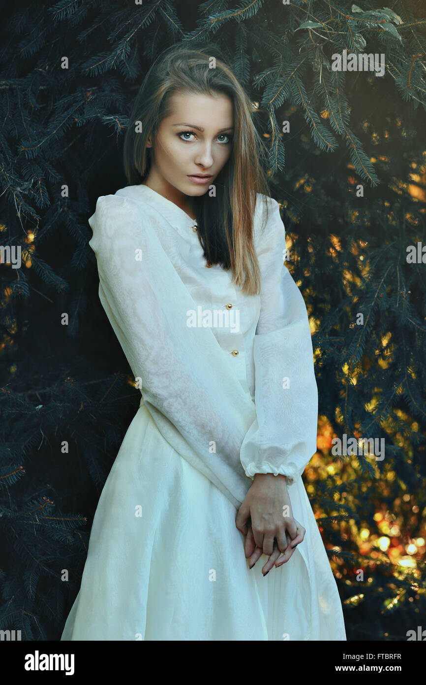 Bella donna che pongono tra i rami di pino . Ritratto di inverno Foto Stock