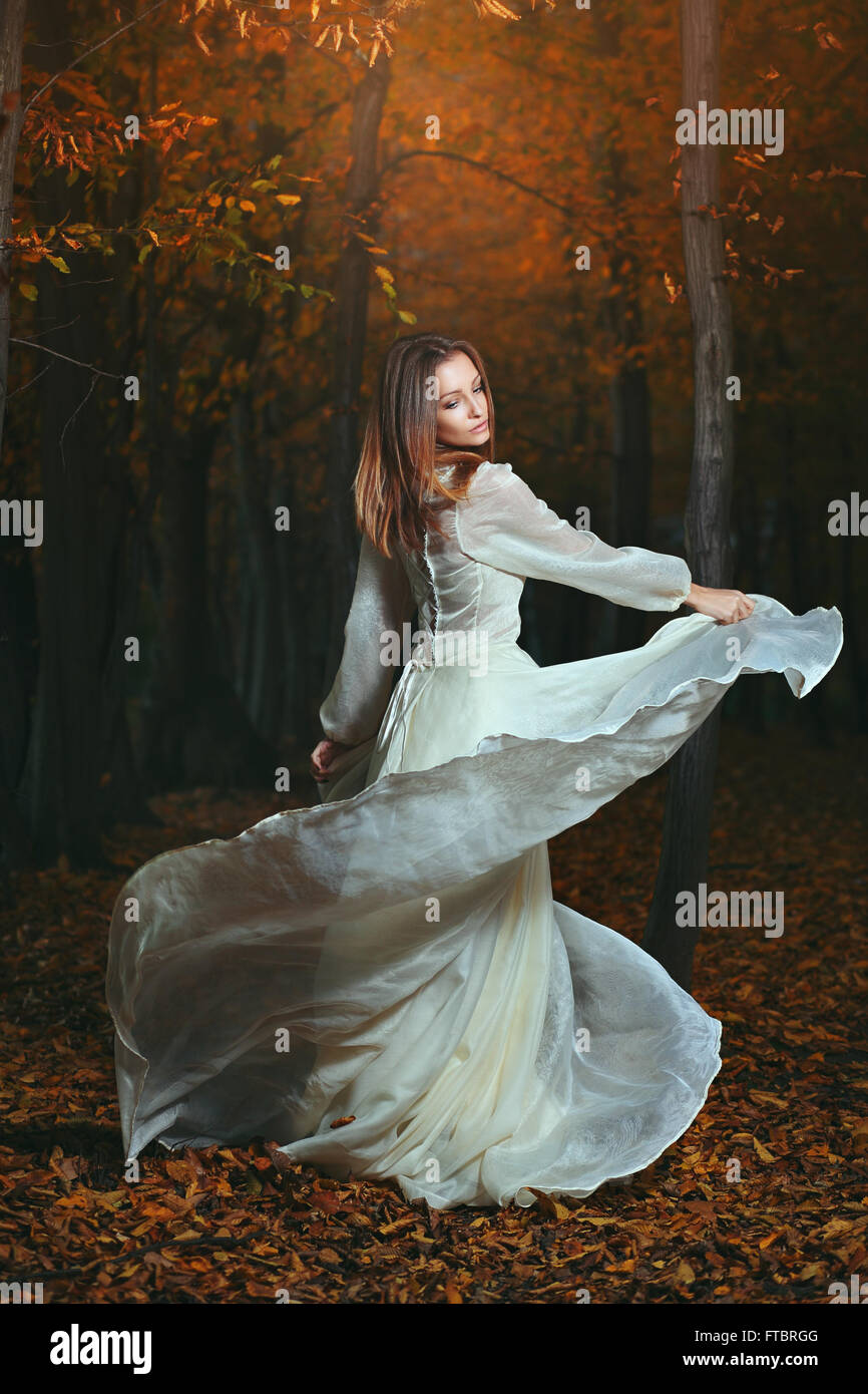 Bella donna dancing in scuri boschi d'autunno. Surreale e fantasia Foto Stock