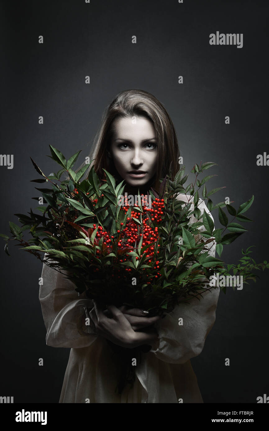 Dark ritratto di una bella donna pallido con il mazzo di fiori di colore rosso . Vampire Foto Stock