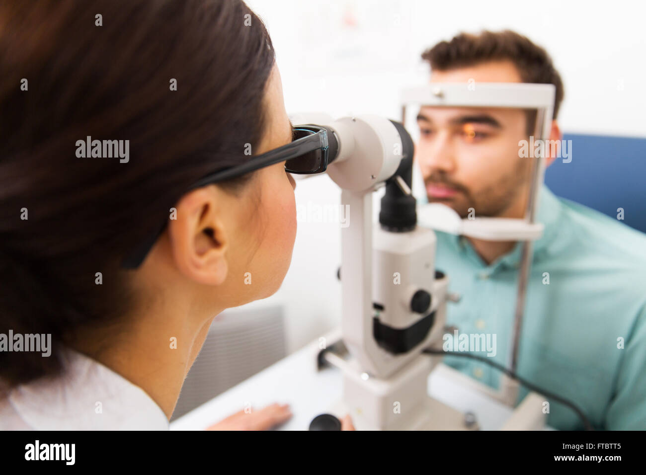 Ottico con lampada a fessura e paziente alla clinica oculistica Foto Stock