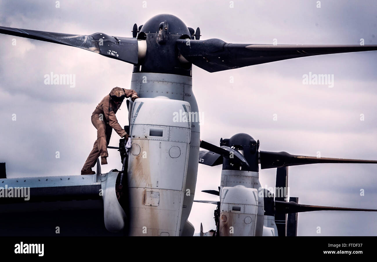 150723-M-JT438-071 Nairobi, Kenya (23 luglio 2015) UN U.S. Marine con il "Grayhawks" del mezzo marino Tiltrotor Squadron 161 (rinforzato), xv Marine Expeditionary Unit (MEU), salviettine giù un MV-22B Osprey dopo il decollo e atterraggio Trapani all'Aeroporto Internazionale Jomo Kenyatta. I marines sono in Kenya per sostenere il Presidente Barrack Obama la visita. Elementi del XV MEU, basato fuori di Camp Pendleton, California, e imbarcato a bordo dell'Essex, stanno conducendo operazioni militari nella flotta di 6 aree di intervento a sostegno degli Stati Uniti per gli interessi di sicurezza nazionali in Europa e in Africa. (U.S. Marine Corps Foto Stock