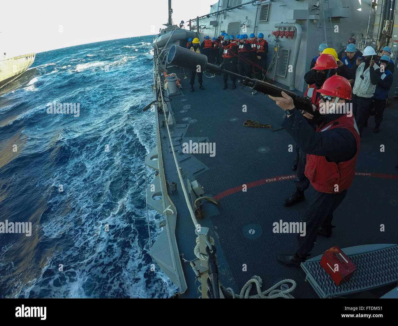 Il Gunner's Mate 2nd Class Corey Dickens spara una linea di tiro dalla USS Carney (DDG 64) durante un rifornimento in mare nel Mediterraneo. Il cacciatorpediniere sta sostenendo la sicurezza nazionale degli Stati Uniti in Europa come parte delle operazioni della 6th Fleet. Foto Stock
