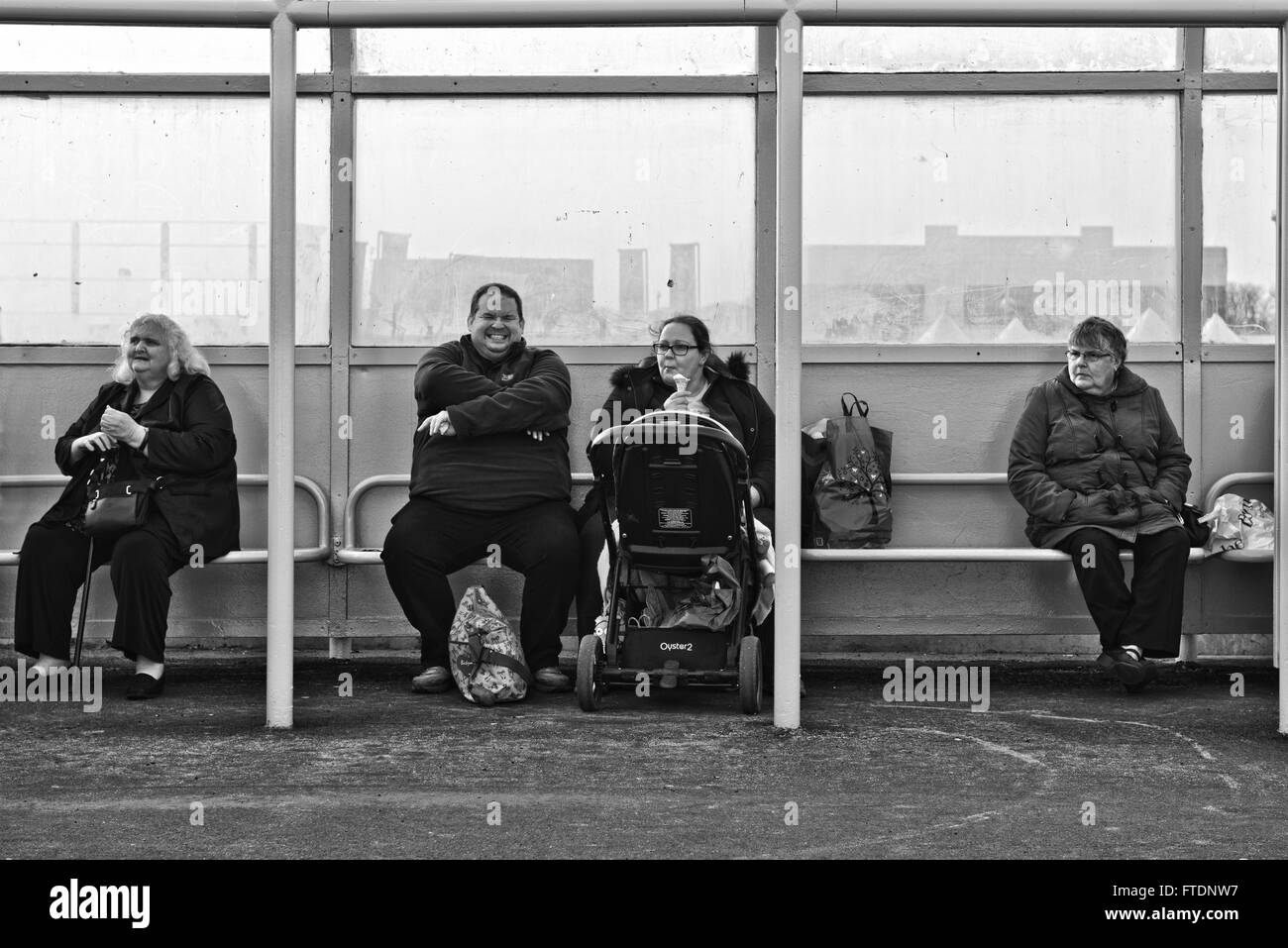 Una candida immagine di quattro persone sovrappeso seduti in una spiaggia rifugio a Skegness, Lincolnshire, Regno Unito Foto Stock
