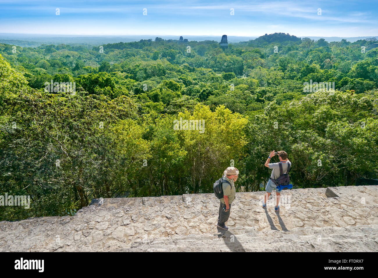 I turisti sulla sommità del tempio IV, le antiche rovine Maya, il Parco Nazionale di Tikal, Yucatan, Guatemala Foto Stock