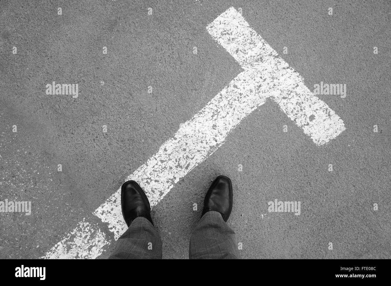 Urbanite man in black nuovi fulgidi scarpe di cuoio in piedi su asfalto con parcheggio la segnaletica stradale Foto Stock