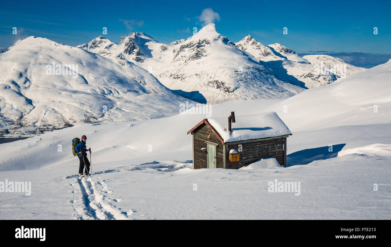 Sci alpinismo alla cabina su Rodtinden con vedute verso il magazzino Blamann e l'oceano aperto, Kvaloya Troms, nel nord della Norvegia Foto Stock