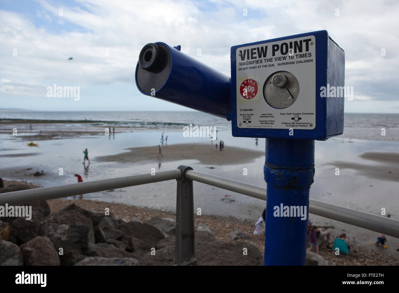 Vacanze a piedi e giocando sulla sabbia di una spiaggia britannico in una scena di tipico british estate meteo, umido e nuvoloso con una mancanza di sole. Foto Stock