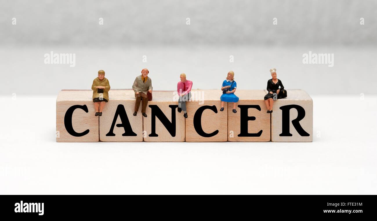 Statuine in miniatura seduta sulla parte superiore della parola il cancro Foto Stock